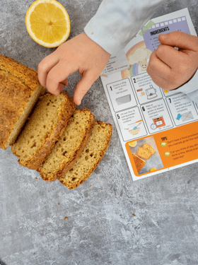 lemon cake recipe card with a child's handing grabbing a slice of cake