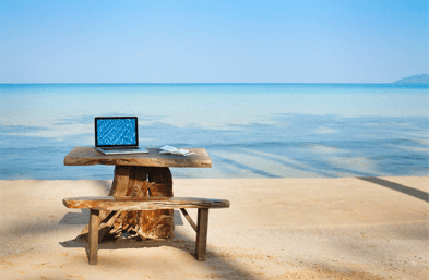 laptop set up on a desk on a beach