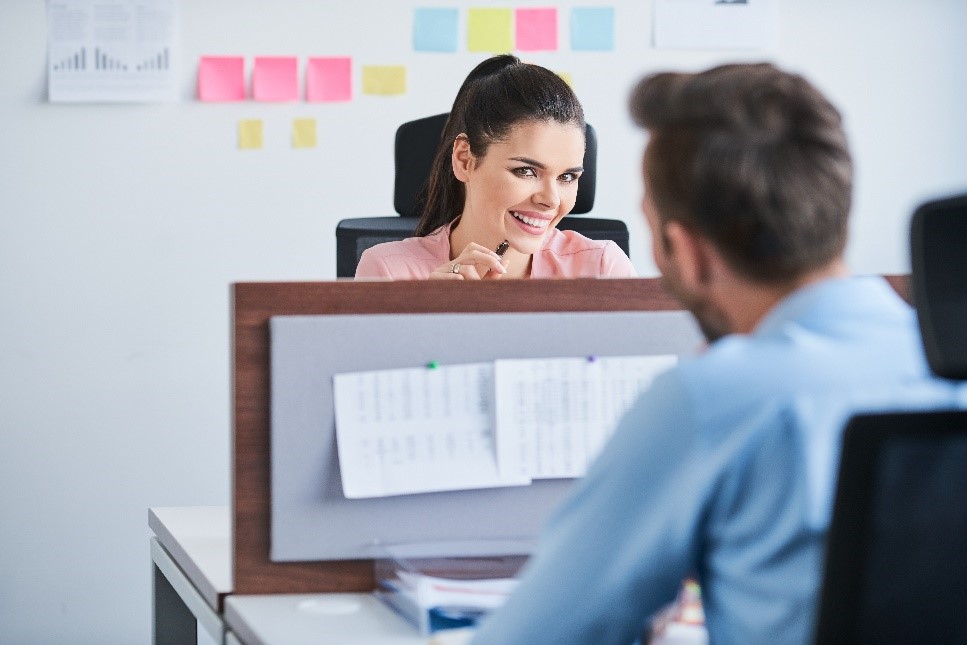 woman looking seductively at a man across the desk