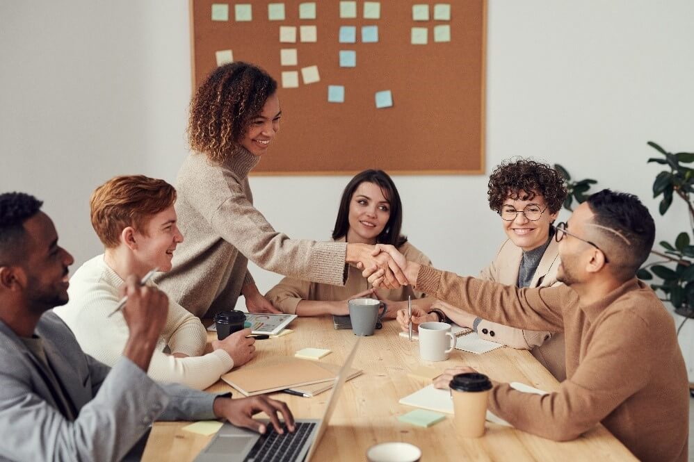 woman shaking someone's hand in a meeting