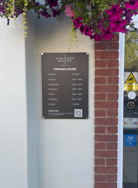 black aluminium opening hours sign outside hair salon