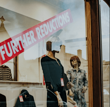 A Christmas sale display with a red sale sticker on the window