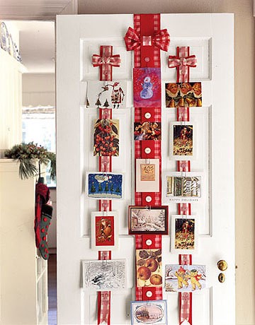 Christmas cards hung on pieces of ribbon on the back of a door