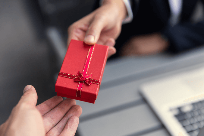 man handing over a red gift box