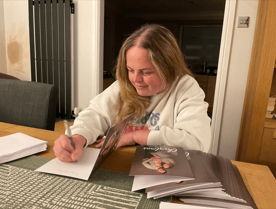 Lady at a table writing out Christmas cards