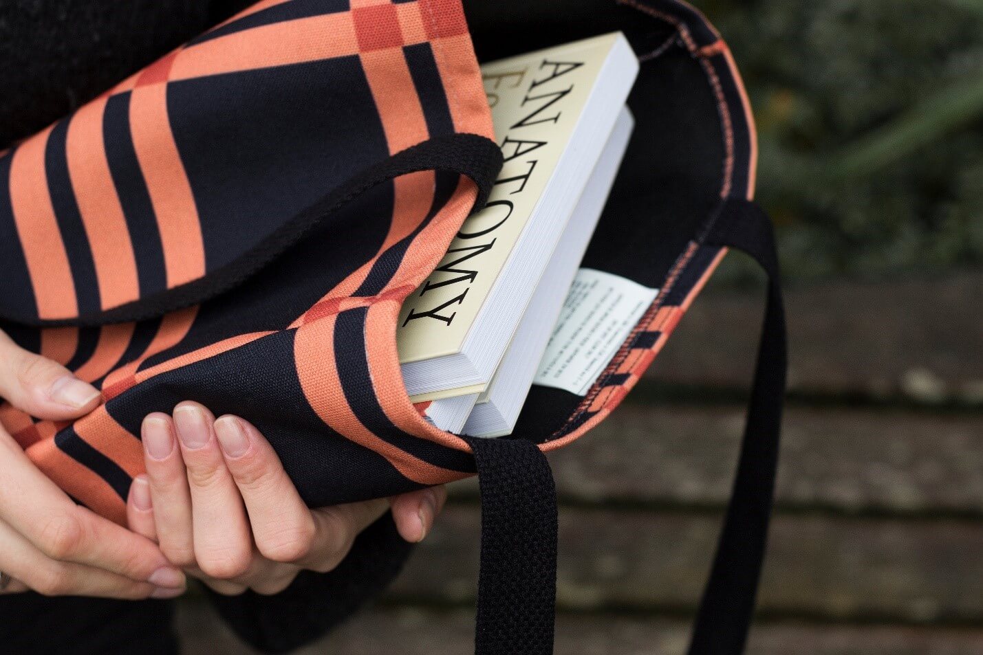 black and orange tote bag filled with books