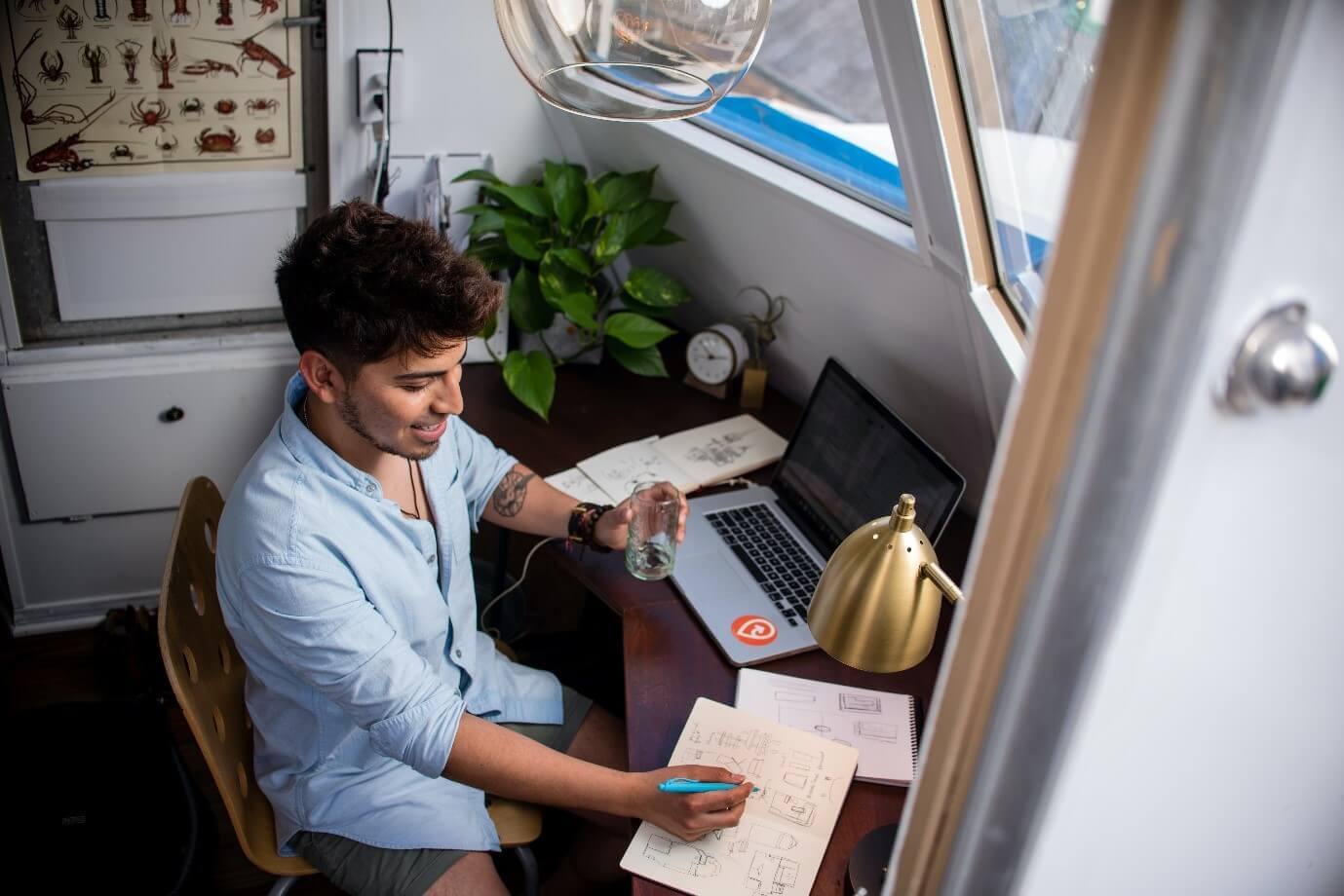 Man working at a desk with a laptop and notebooks