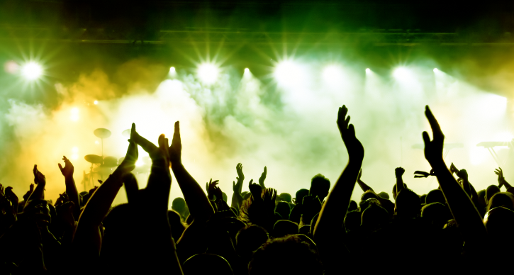 silhouettes of hands at a music festival stage