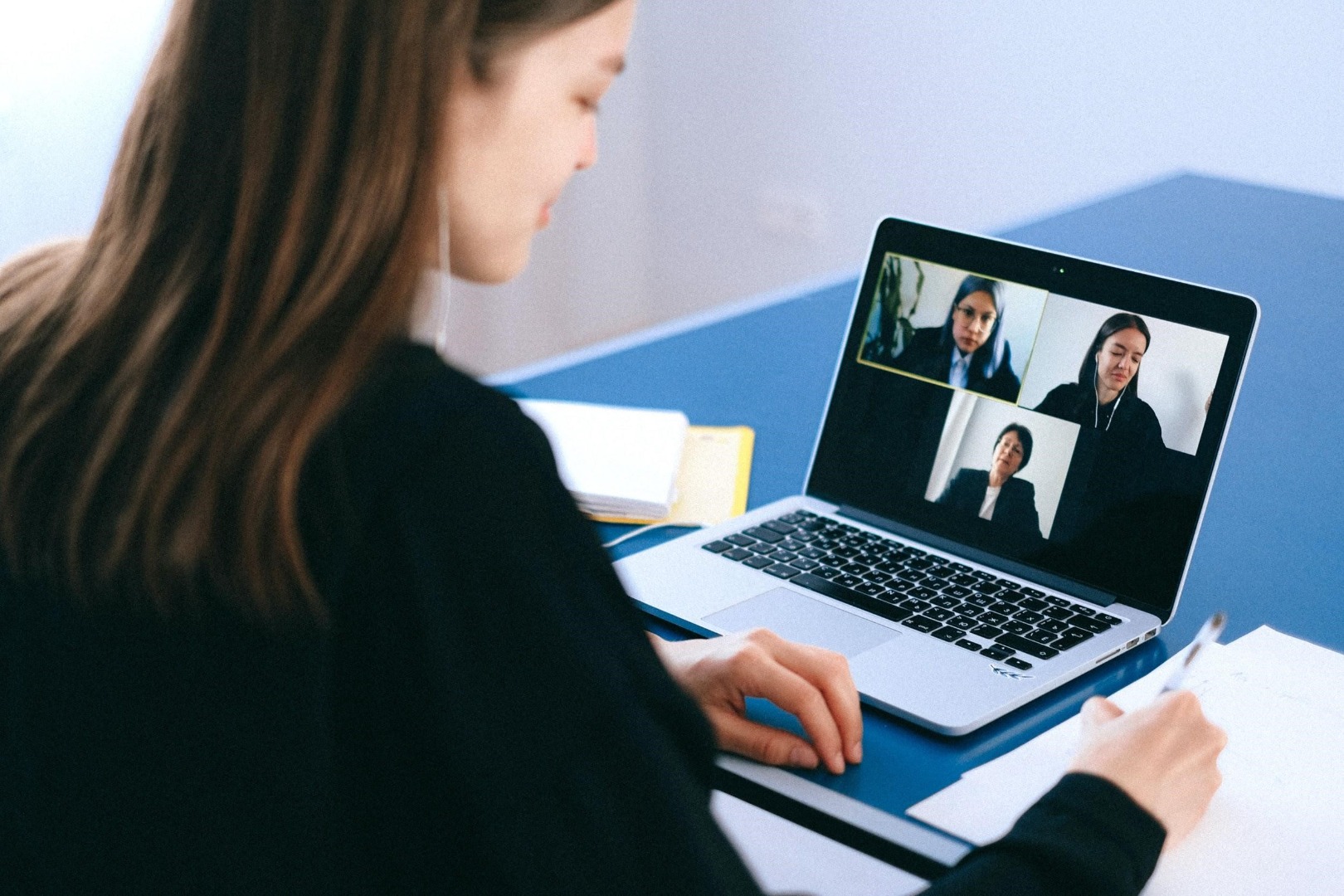 woman talking to colleagues via video call on a laptop