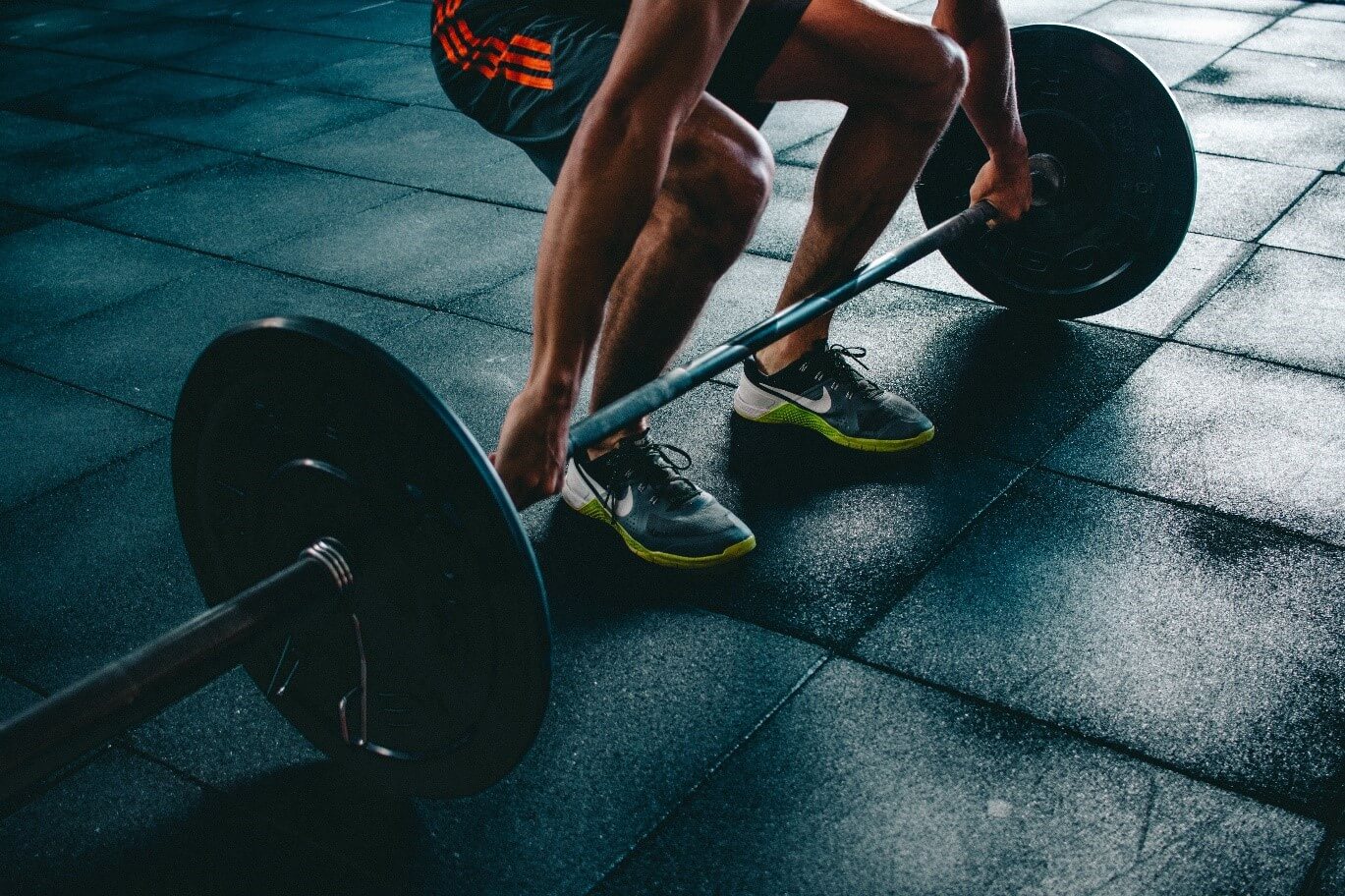 man in a gym lifting barbell weights