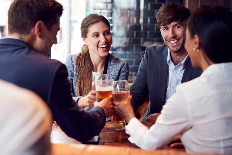 young professionals in a pub drinking beer and wine