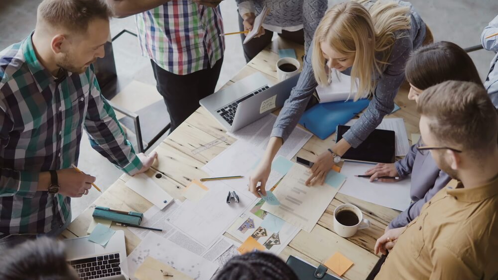 work team collaborating at a table full of paper