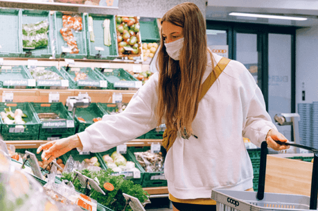 woman shopping in a supermarket wearing a face covering